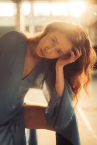 A woman sitting on a bench with her hand on her head