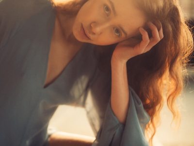 A woman sitting on a bench with her hand on her head