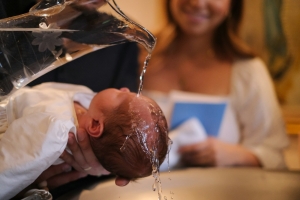 A baby being washed in a kitchen sink